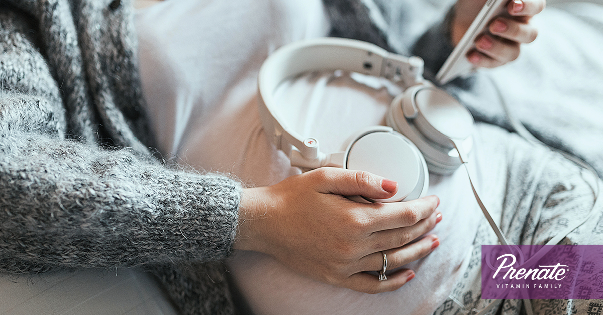 Pregnant mother holding headphones to her belly
