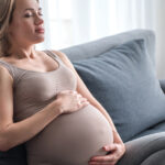 Pregnant women deep breathing on couch